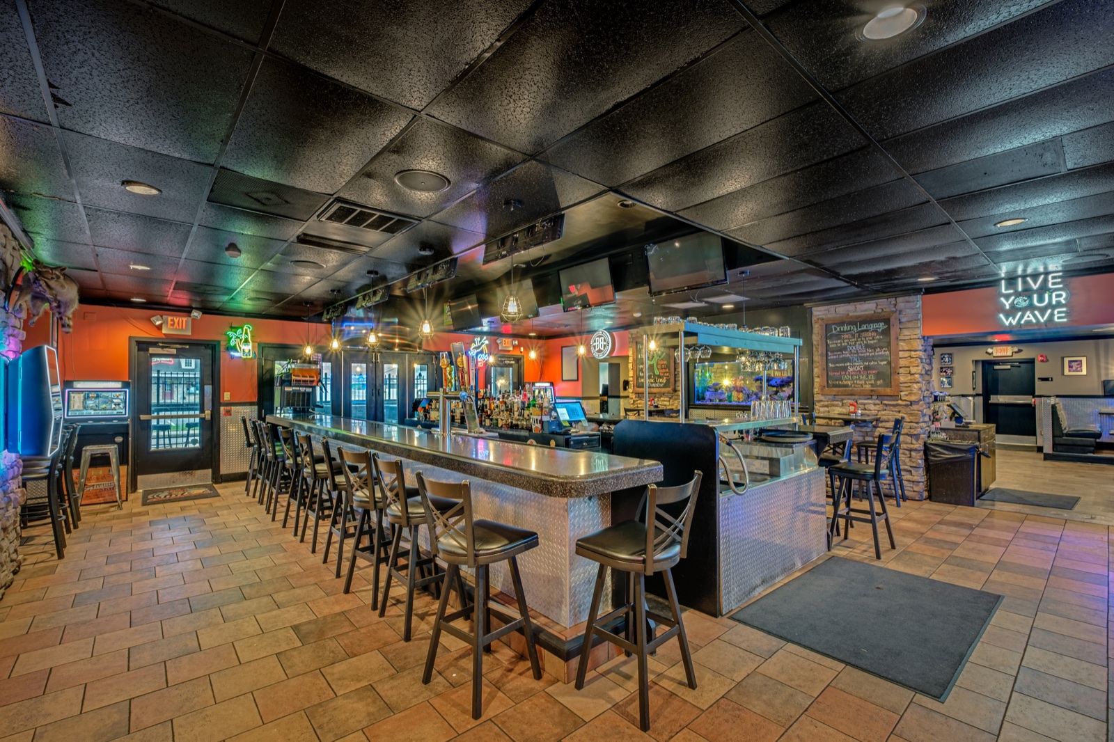 Highspire restaurant bar with metal finishes, neon accents, surrounding seating, and an illuminated aquarium