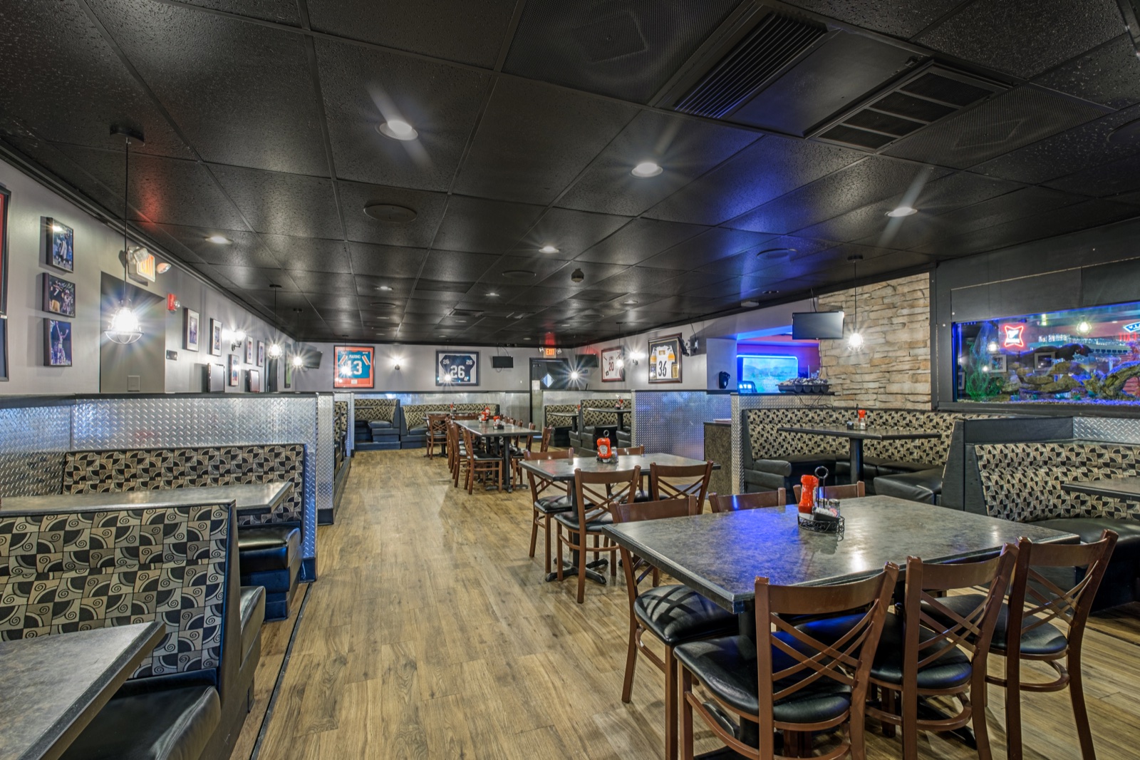 Restaurant dining room in Highspire with booths, tables, framed sports memorabilia, and an illuminated aquarium
