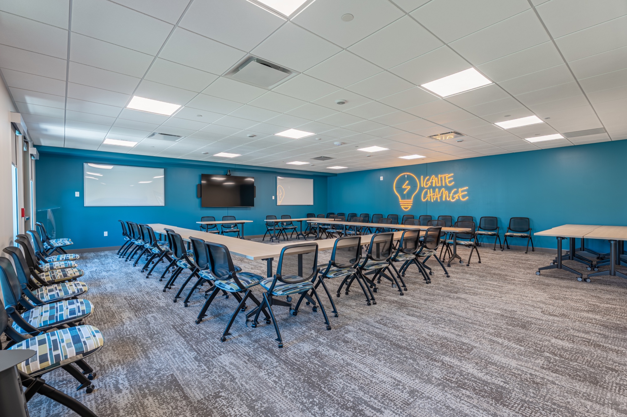 Mission Kids training room with flexible seating and a glowing Ignite Change sign