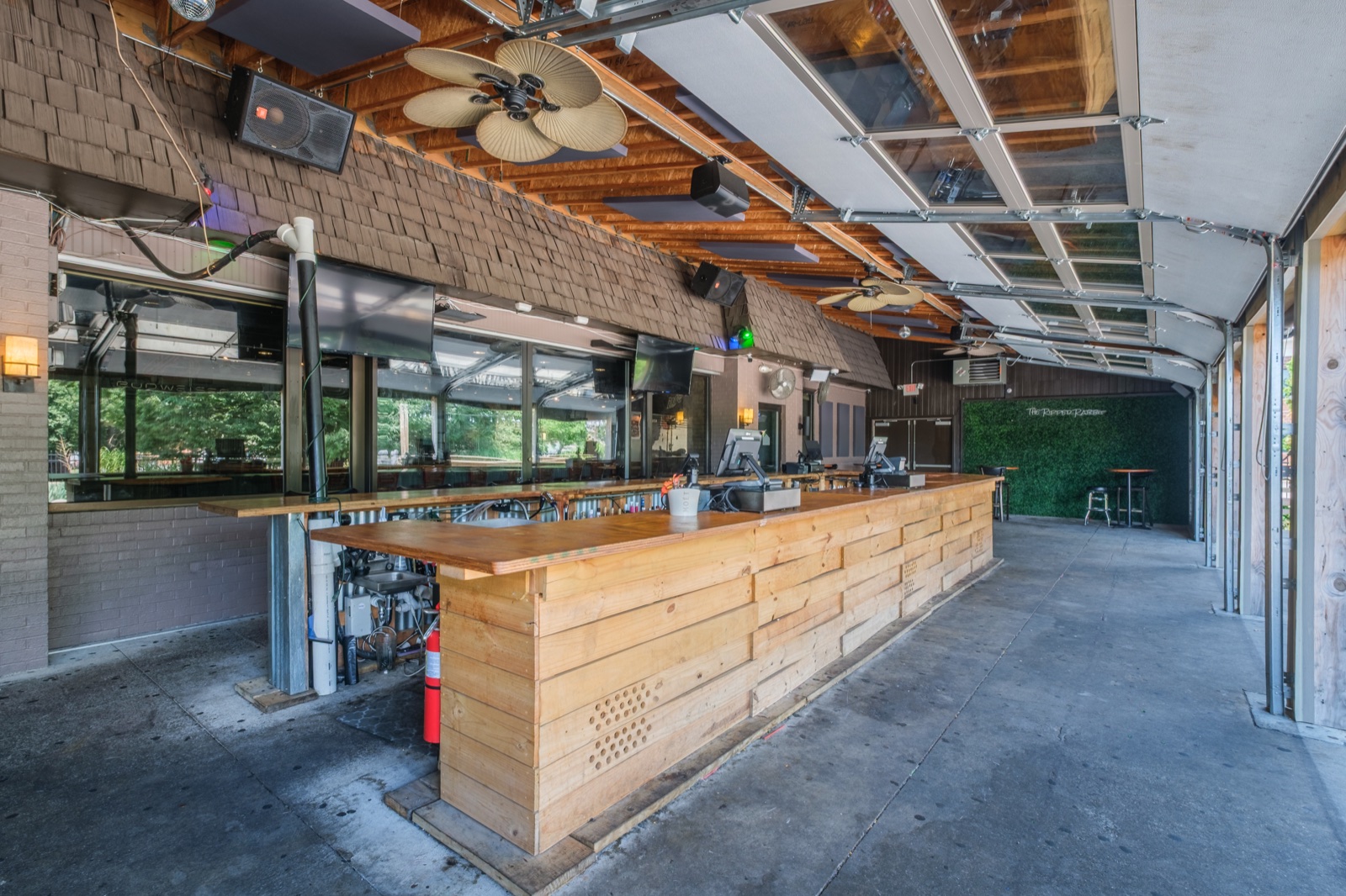 Covered outdoor restaurant bar with an operable glass wall