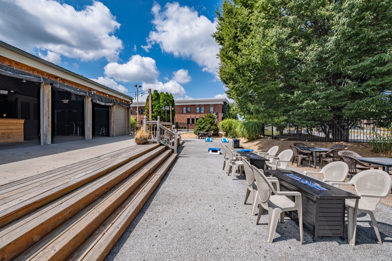 Outdoor restaurant patio with seating, games, and a small stage